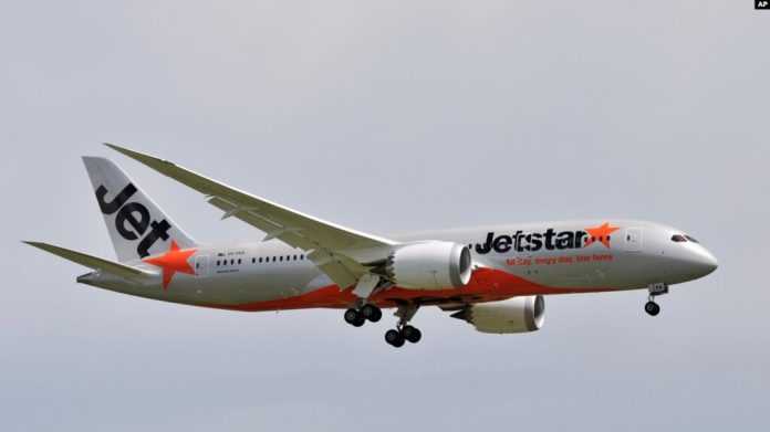 Un hombre abre la puerta de un avión y camina por el ala antes de ser arrestado