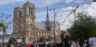 Peatones caminan cerca de la emblemática catedral de Notre Dame de Francia, horas antes de reabrir formalmente sus puertas por primera vez desde que un devastador incendio casi destruyó el monumento de 861 años de antigüedad en 2019, el sábado 7 de diciembre de 2024, en París.